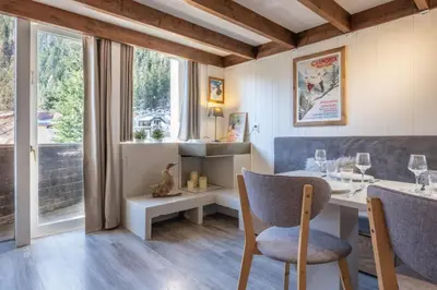 a dining room with a table and chairs and a window at Beautiful Apt near the Grands Montets slopes in Chamonix-Mont-Blanc