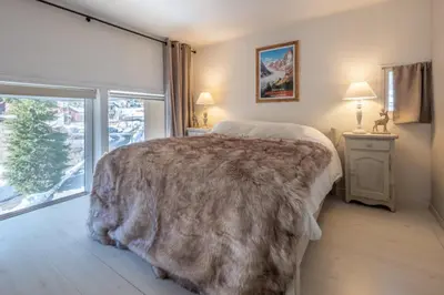a bedroom with a large bed and a large window at Beautiful Apt near the Grands Montets slopes in Chamonix-Mont-Blanc