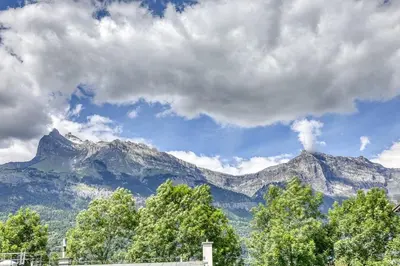 a view of a mountain range with trees and clouds at Appartement Cosy - 1 à 2 chambres proche thermes et ski in Saint-Gervais-les-Bains