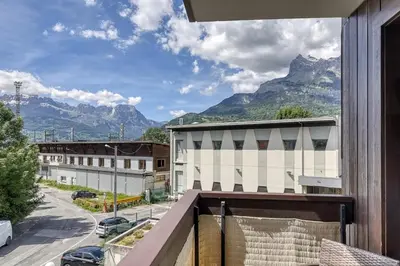 a balcony with a view of a street and mountains at Appartement Cosy - 1 à 2 chambres proche thermes et ski in Saint-Gervais-les-Bains