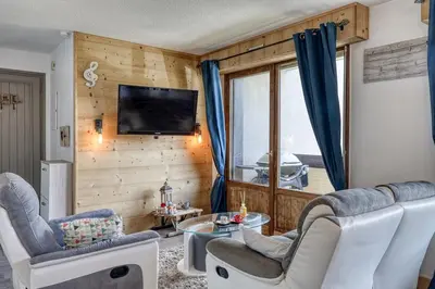 a living room with two chairs and a table and a tv at Appartement Cosy - 1 à 2 chambres proche thermes et ski in Saint-Gervais-les-Bains