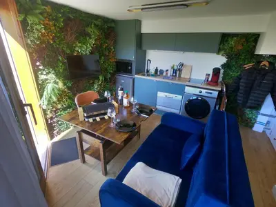 a living room with a blue couch and a table at Jungle room au centre des Carroz in Les Carroz d'Araches