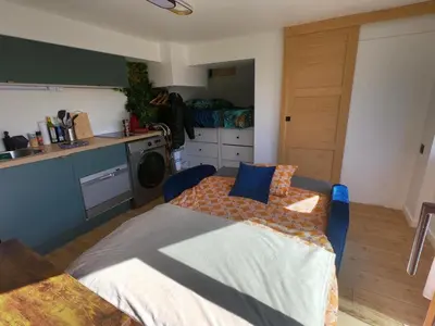 a bedroom with a bed in the middle of a kitchen at Jungle room au centre des Carroz in Les Carroz d'Araches