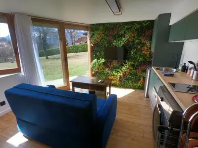 a kitchen with a plant wall with a blue chair at Jungle room au centre des Carroz in Les Carroz d'Araches