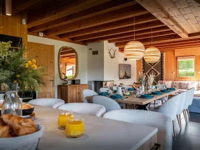 a dining room with a long table and white chairs at Chalet OCimes - OVO Network in Samoëns