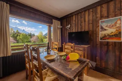 a dining room with a table and a large window at Résidence Améthystes B02 ski in ski out - Happy Rentals in Chamonix-Mont-Blanc