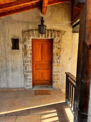 a wooden door on the side of a stone building at Appartement Saint-Gervais in Saint-Gervais-les-Bains