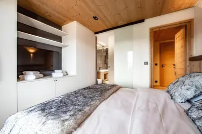 a bedroom with a bed and a wooden ceiling at Appartement de charme au pied des pistes de Cordon in Cordon