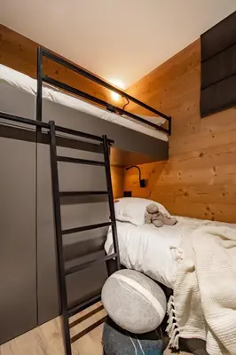 a bedroom with two bunk beds and a ladder at Appartement de charme au pied des pistes de Cordon in Cordon