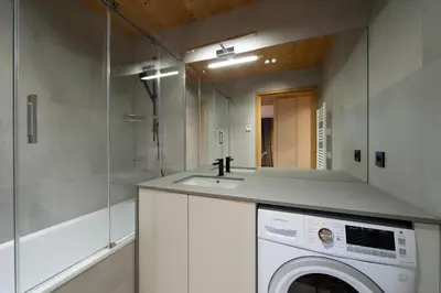 a bathroom with a washing machine and a sink at Appartement de charme au pied des pistes de Cordon in Cordon