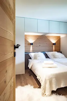 a bedroom with a large bed with white pillows at Appartement de charme au pied des pistes de Cordon in Cordon