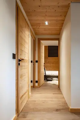 a hallway leading to a bedroom with wooden walls at Appartement de charme au pied des pistes de Cordon in Cordon