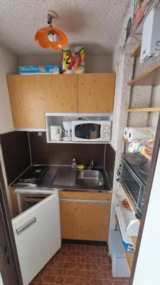 a small kitchen with a sink and a microwave at Studio Vue Montagne, Skis aux pieds, Garage inclus in Samoëns