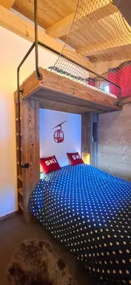 a bed in a room with a net at Chalet des Ours - 2 appartements 4 étoiles premium - 5 ou 6 personnes in Les Contamines-Montjoie