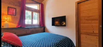 a bedroom with a bed and a window at Chalet des Ours - 2 appartements 4 étoiles premium - 5 ou 6 personnes in Les Contamines-Montjoie