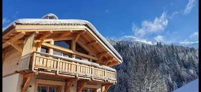 a log cabin with snow on the top of it at Chalet des Ours - 2 appartements 4 étoiles premium - 5 ou 6 personnes in Les Contamines-Montjoie