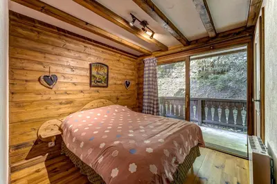 a bedroom with a bed in a room with a window at Jardin du Parc Mont Blanc- Alpine Style apartment in the Heart of Chamonix in Chamonix-Mont-Blanc