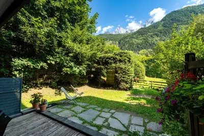 a view of a garden from the deck of a house at Jardin du Parc Mont Blanc- Alpine Style apartment in the Heart of Chamonix in Chamonix-Mont-Blanc