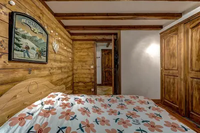 a bedroom with a bed in a room with wooden walls at Jardin du Parc Mont Blanc- Alpine Style apartment in the Heart of Chamonix in Chamonix-Mont-Blanc