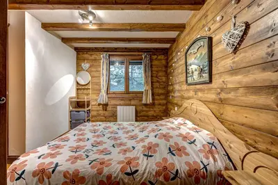 a bedroom with a bed in a log cabin at Jardin du Parc Mont Blanc- Alpine Style apartment in the Heart of Chamonix in Chamonix-Mont-Blanc