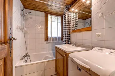 a bathroom with a tub and a sink and a bath tub at Jardin du Parc Mont Blanc- Alpine Style apartment in the Heart of Chamonix in Chamonix-Mont-Blanc