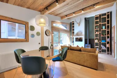 a living room with a table and a couch at SANTA MARIA MEGEVE proche village in Megève