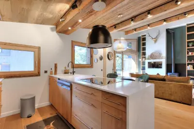 a kitchen with a sink and a living room at SANTA MARIA MEGEVE proche village in Megève
