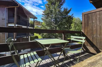 a table and two chairs sitting on a deck at SANTA MARIA MEGEVE proche village in Megève