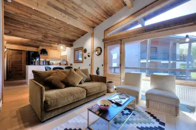 a living room with a couch and a table at SANTA MARIA MEGEVE proche village in Megève