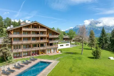 a large house with a swimming pool next to a yard at Alto in Combloux