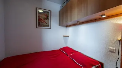 a room with a red blanket on a wall at Les Eterlous N35 - 2P4 in Morillon