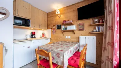 a kitchen with a table and chairs and a kitchen with a television at Les Eterlous N35 - 2P4 in Morillon