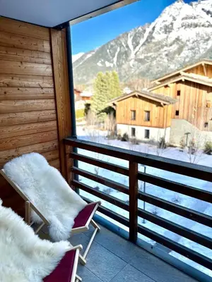a balcony with chairs and a view of a snow covered mountain at CHAMONIX Résidence La Cordée avec Piscine et Spa - Appartement 126 in Chamonix-Mont-Blanc