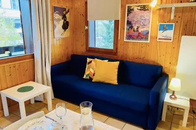 a living room with a blue couch and a table at Apartment In Downtown Chamonix in Chamonix-Mont-Blanc