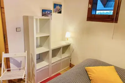 a room with a white book shelf next to a bed at Apartment In Downtown Chamonix in Chamonix-Mont-Blanc