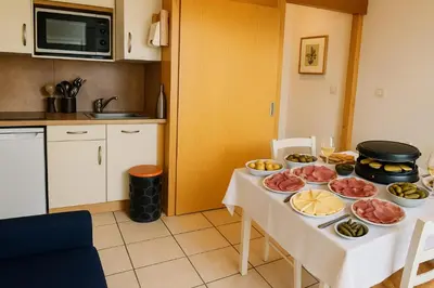 a table with plates and wine glasses in a living room at Apartment In Downtown Chamonix in Chamonix-Mont-Blanc
