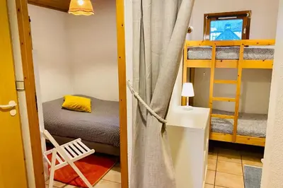 a small kitchen with white cabinets and a microwave at Apartment In Downtown Chamonix in Chamonix-Mont-Blanc