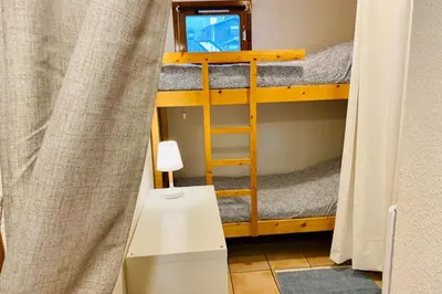 a small room with a bunk bed and a ladder at Apartment In Downtown Chamonix in Chamonix-Mont-Blanc