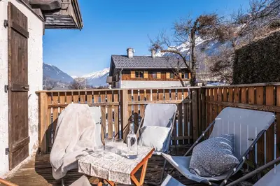 a patio with two chairs and a table on a deck at Duplex T3 with terrace in Chamonix in Chamonix-Mont-Blanc