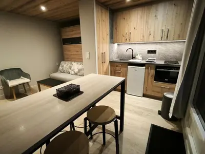 a kitchen with a table and chairs in a room at Appartement vue imprenable montagne in Samoëns
