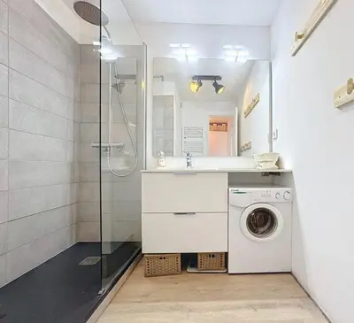 a bathroom with a washing machine and a shower at Appartement vue imprenable montagne in Samoëns