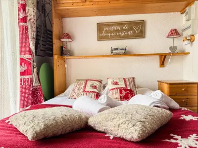 a bed with two pillows on top of it at Charmant Studio Avec Terrasse By TerraAlpina in Saint-Gervais-les-Bains
