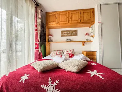 a red bed with snowcovered pillows on it at Charmant Studio Avec Terrasse By TerraAlpina in Saint-Gervais-les-Bains