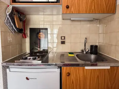 a small kitchen with a sink and a stove at Charmant Studio Avec Terrasse By TerraAlpina in Saint-Gervais-les-Bains