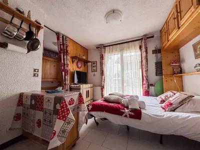 a bedroom with a bed and a table in it at Charmant Studio Avec Terrasse By TerraAlpina in Saint-Gervais-les-Bains
