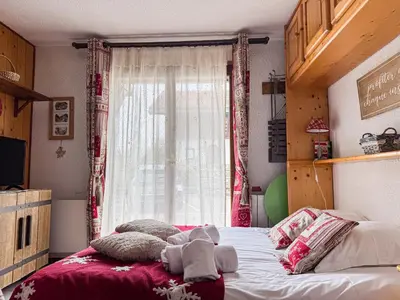 a bedroom with a large bed with a window at Charmant Studio Avec Terrasse By TerraAlpina in Saint-Gervais-les-Bains
