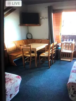 a dining room with a table and chairs and a tv at Appartement Cosy in Les Carroz d'Araches