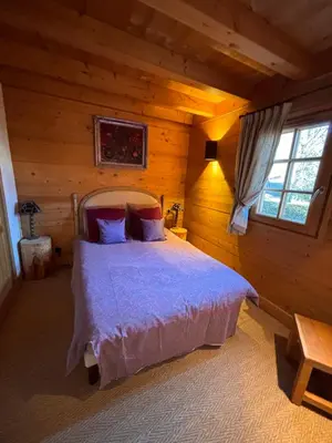 a bedroom with a bed in a log cabin at Appartement duplex megeve in Megève