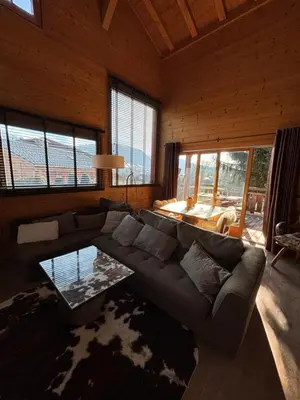 a living room with a couch and a table at Appartement duplex megeve in Megève