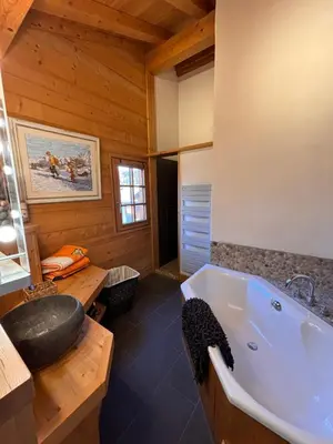 a bathroom with a tub in a wooden cabin at Appartement duplex megeve in Megève
